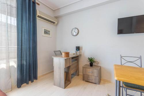 a room with a desk and a clock on the wall at Mellow Vibes in Volos