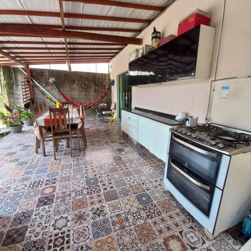 a kitchen with a stove and a table at COP30 Casa Completa - Prox Belém in Barcarena