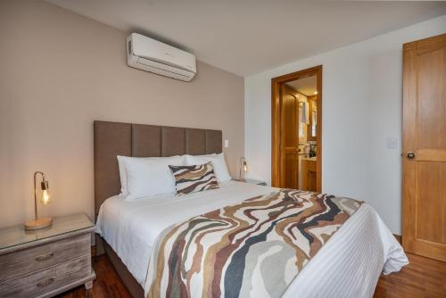 a bedroom with a large bed with a wooden headboard at Alcazar de Oviedo by EE Hoteles in Medellín