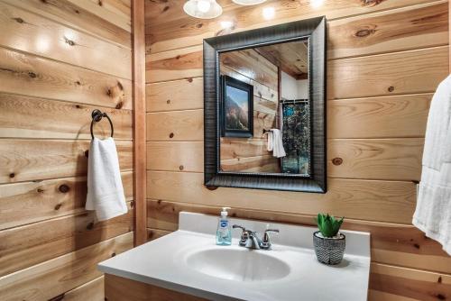 a bathroom with a sink and a mirror at Smoky Mountain Splash in Sevierville