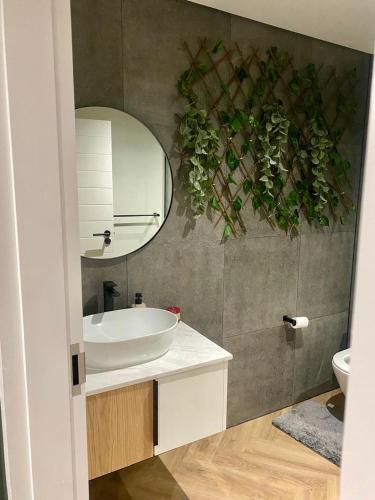 a bathroom with a sink and a mirror at On Park Century City Cozy Apartment in Cape Town