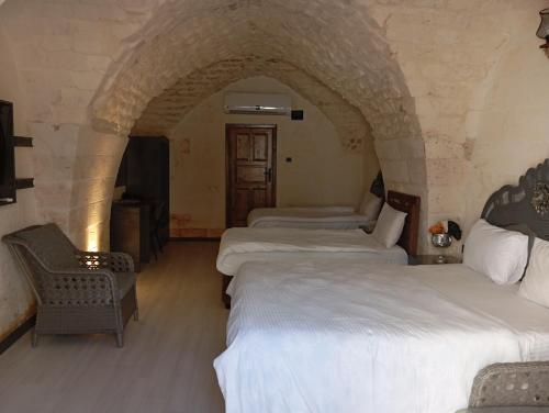 a group of four beds in a room at Aslan Guest House in Sanlıurfa