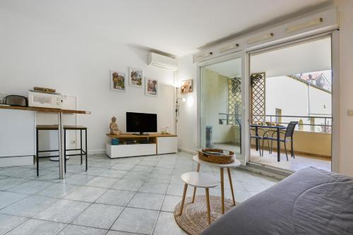 un salon avec un canapé et une télévision dans l'établissement Magnifique studio au calme, Climatisation, Parking, Wifi., à Beaulieu-sur-Mer