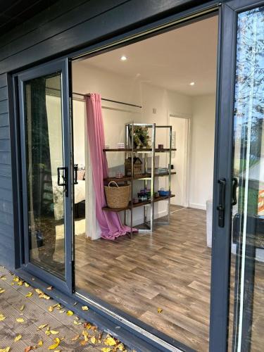 a sliding glass door of a house with a room at Farm woodland riverview cabin bbq firepit pet friendly in Hertford