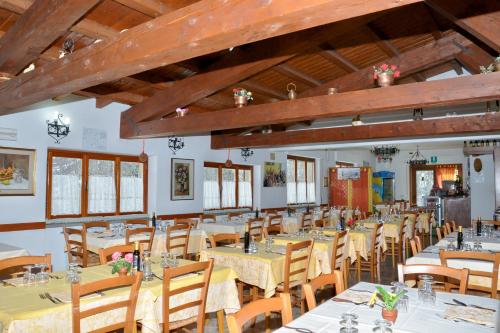 a dining room with tables and chairs and wooden ceilings at La Casetta in Cutigliano