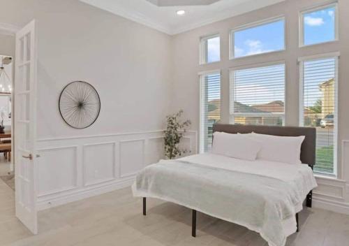 a white bedroom with a bed and a window at 298 5 Bedrooms Fenced yard New Construction in Robstown
