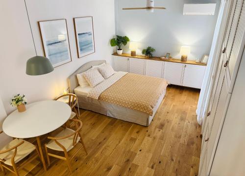 a small bedroom with a bed and a table at SEAESTA Cosy Sea Apartment in Koper