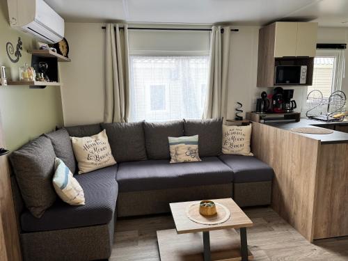 a living room with a couch and a kitchen at Location Mobil-Home "Le Piriac'Home V2" in Piriac-sur-Mer