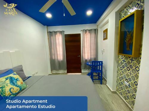 a bedroom with a bed with a blue ceiling at Casa María in Isla Mujeres