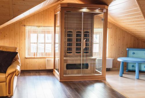 a glass shower in a room with a table at Apartamenty pod Zamkiem in Łapalice