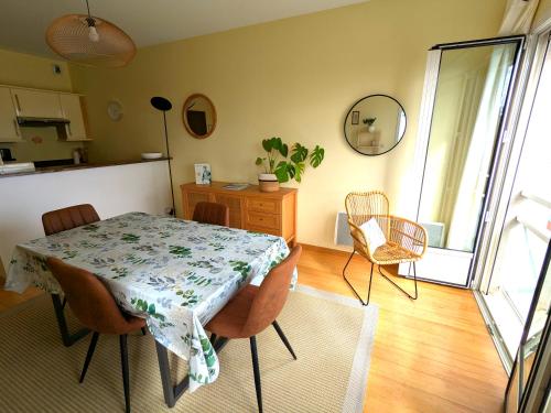 une salle à manger avec une table et des chaises dans une pièce dans l'établissement Duplex vue mer tout confort a la Croix Paqueray, à Carolles