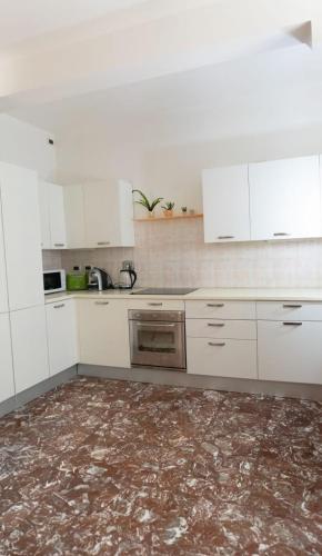 a kitchen with white cabinets and a marble floor at Casarosa in Porretta Terme