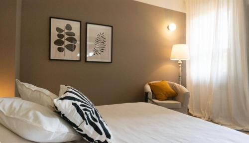 a bedroom with a white bed and a chair at Casarosa in Porretta Terme