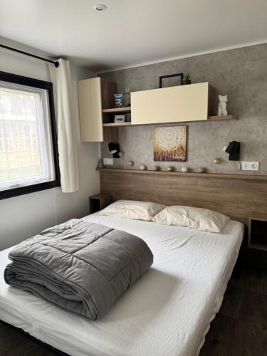 a bedroom with a large bed with a white bedspread at Location Mobil-Home "Le Piriac'Home V2" in Piriac-sur-Mer