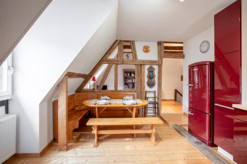 une cuisine avec une table et un réfrigérateur rouge dans l'établissement L'Atypique au coeur du Vignoble, à Hunawihr