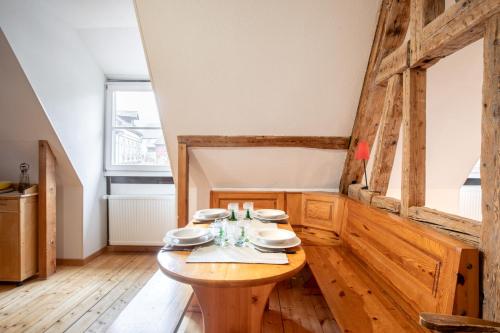 a wooden table in a room with a wooden floor at L'Atypique au coeur du Vignoble in Hunawihr