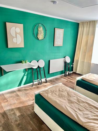 a bedroom with two beds and a green wall at Your Home Away #Worker Accommodation in Erkrath