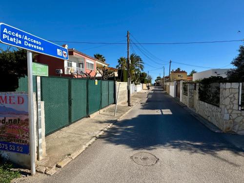 an empty street with a fence and a street sign at Relax time! in Casas Devesa