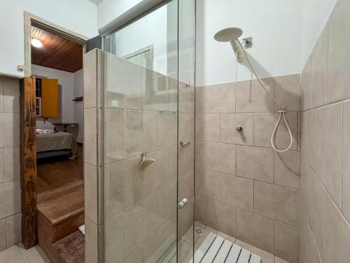 a shower with a glass door in a bathroom at Jardim da Música Tiradentes in Tiradentes