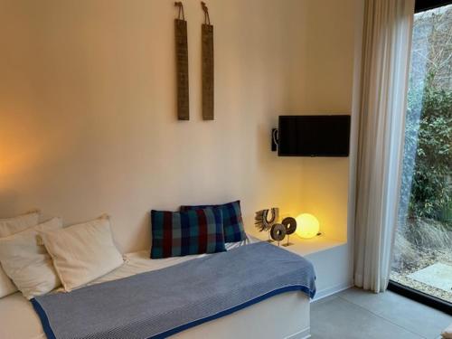 a bedroom with a bed and a window with a television at Oscarsleeps in Ghent