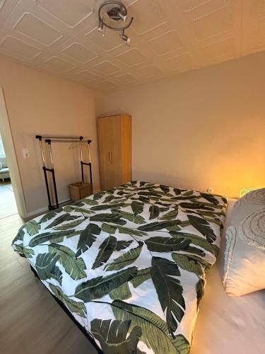 a bedroom with a bed with a green and white comforter at FeWo am Mainplatz in Teltow