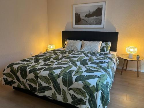 a bedroom with a bed with a green and white comforter at FeWo am Mainplatz in Teltow