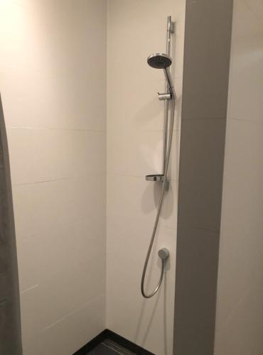 a shower with a shower head in a bathroom at de drie populieren in Losser