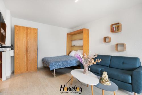 - un salon avec un canapé bleu et un lit dans l'établissement Studio Cosy, Emplacement Idéal 2 minute des plages, à Vallauris