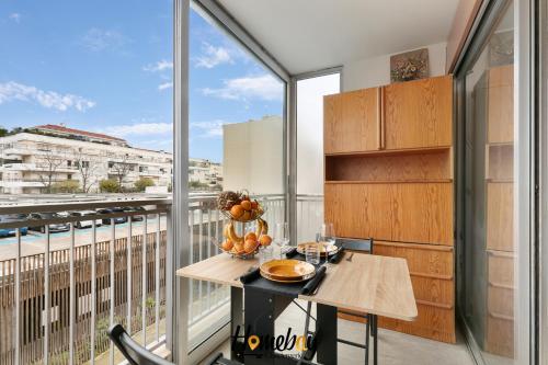 d'un balcon avec une table et une grande fenêtre. dans l'établissement Studio Cosy, Emplacement Idéal 2 minute des plages, à Vallauris