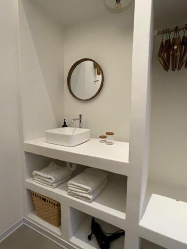 a white bathroom with a sink and a mirror at Oscarsleeps in Ghent