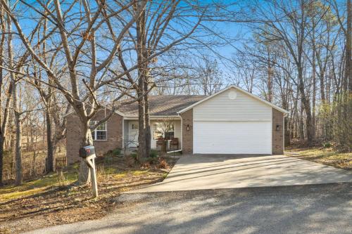 a person standing in front of a house with a garage at Rockrider House-MTB Trail-Pet Friendly in Bella Vista