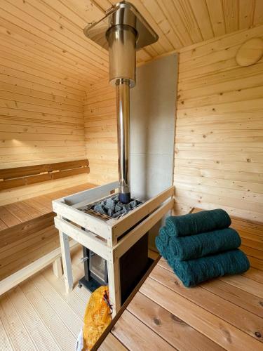 a sauna with a stove in a wooden room at Lobsters Lodge in Heinkenszand ' Wellness Accommodation with Wood-Fired Hottub, Private Sauna and Outdoor Shower ' Airco's ' Free Wifi ' Complimentary Bed linen and Towels in Heinkensand