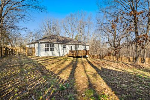 a small white house in a field with trees at Rockrider House-MTB Trail-Pet Friendly in Bella Vista