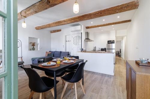une salle à manger et un salon avec une table et des chaises dans l'établissement Sicardi 2 - Plage - Climatisation-vue mer, à Menton