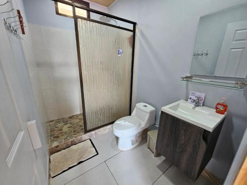 a bathroom with a toilet and a shower and a sink at Ballena Rey Hotel in Uvita