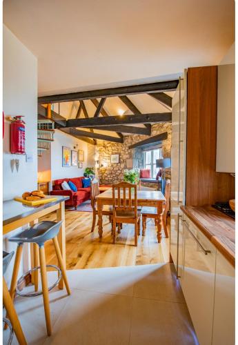 a kitchen and living room with a table and chairs at The Wheel House in Penzance