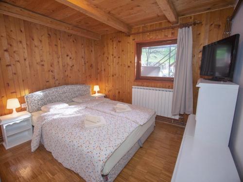 a bedroom with a bed and a tv in a room at OraHouse in Orahovica