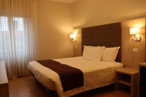 a hotel room with a bed and a window at Hotel Montereale in Pordenone