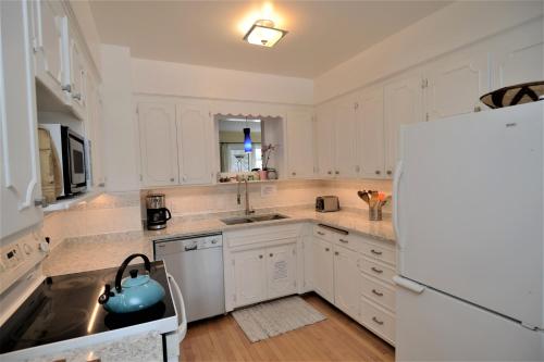 a kitchen with white cabinets and a blue tea kettle at U of A Homestay, Trails & Whyte Ave in Edmonton