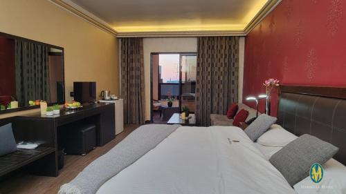 a bedroom with a large bed and a living room at Marbella Hotel in Jounieh