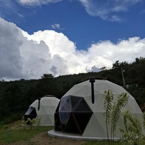 two tents in a field with trees in the background at Embaúba Boutique Hotel in Teresópolis