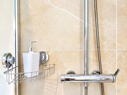 a shower with a roll of toilet paper on a shelf at Le Cobalt - Parking Gratuit, Unique & Central in Saint-Brieuc
