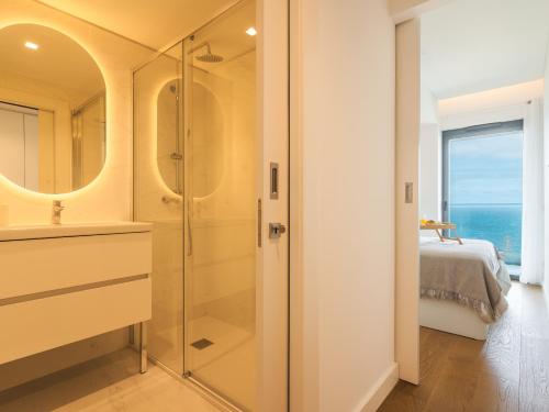 Un baño con ducha de cristal y una cama. en Glamorous Apartment by Atlantic Holiday, en Funchal