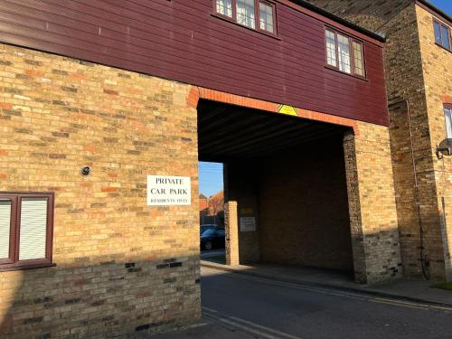 a brick building with a garage with a sign on it at 5 Town centre, entire flat, free parking king bed in Huntingdon