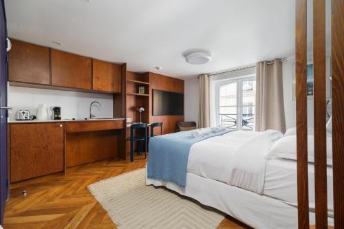 une chambre avec un grand lit et une cuisine dans l'établissement Paris La Belle - Marais, à Paris