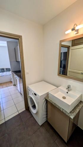 une salle de bain avec une machine à laver et un lavabo dans l'établissement Appartement 30m2 Sète centre ville, à Sète