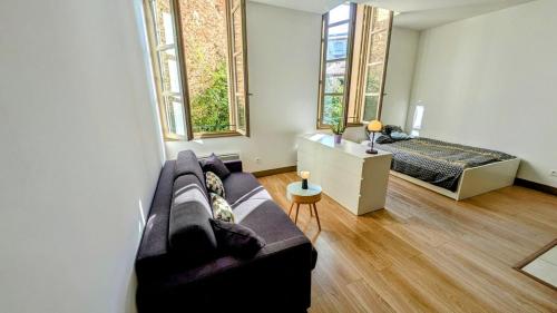 un salon avec un canapé et un lit dans l'établissement Appartement 30m2 Sète centre ville, à Sète