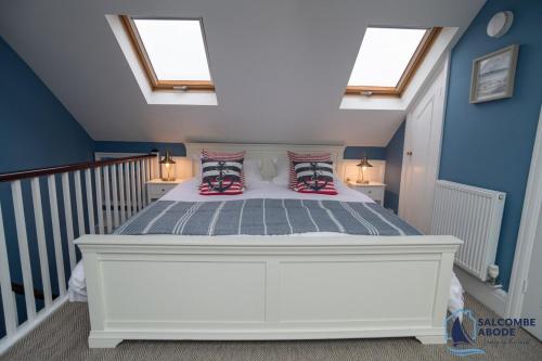 a bedroom with a white bed with pillows on it at Stylish Sanctuary - Estuary Views - Outside Space in Salcombe