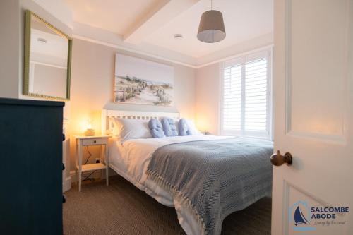 Un dormitorio con una cama con almohadas azules. en Stylish Sanctuary - Estuary Views - Outside Space, en Salcombe