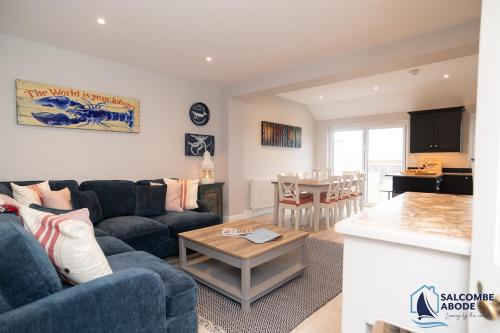 a living room with a couch and a table at Stylish Sanctuary - Estuary Views - Outside Space in Salcombe